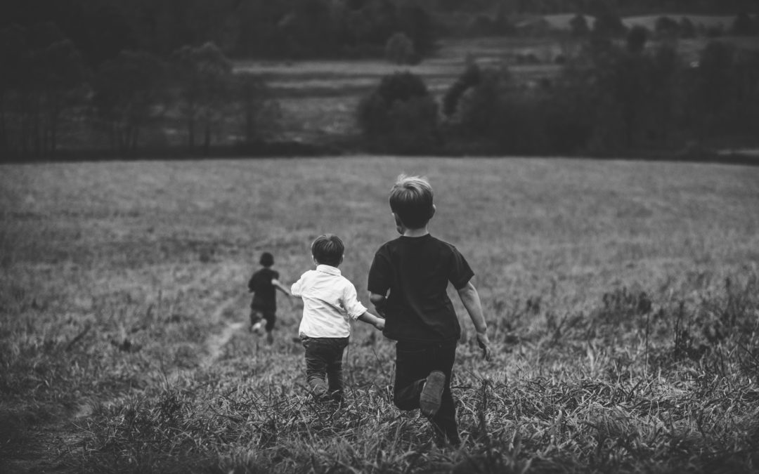 Boys running through a field